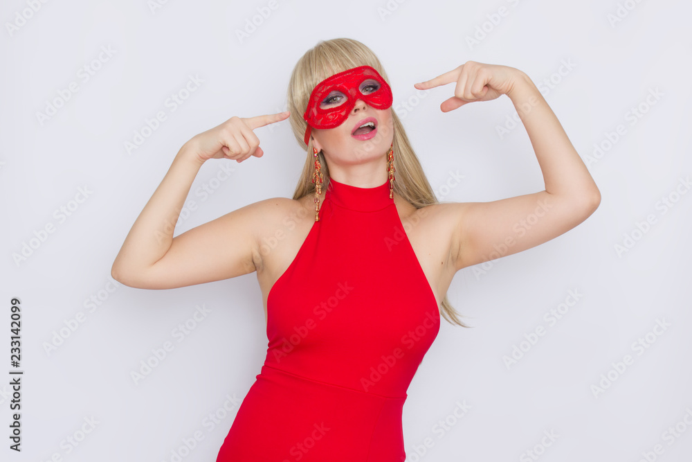 Woman in red dress put carnival mask over white background Woman in red dress put carnival mask over white background