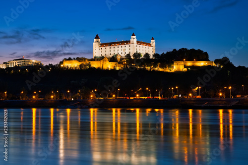 Bratislava castle at night  city lights reflection in Danube river