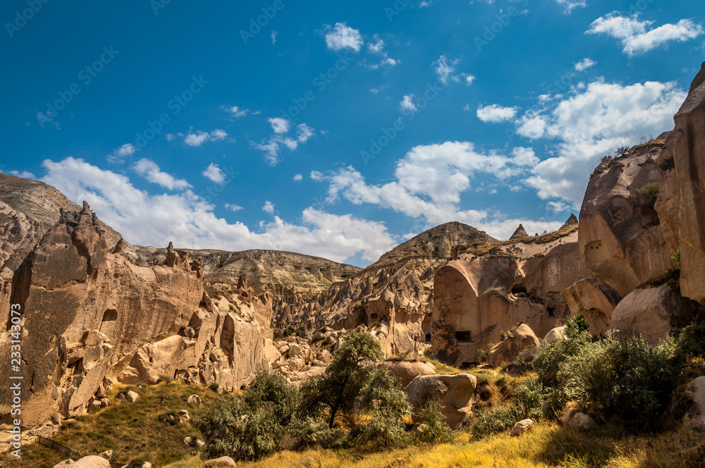 Fototapeta premium View from the structure of Cappadocia. Impressive fairy chimneys of sandstone in the canyon near Cavusin village, Cappadocia, Nevsehir Province in the Central Anatolia Region of Turkey. Overcast sky