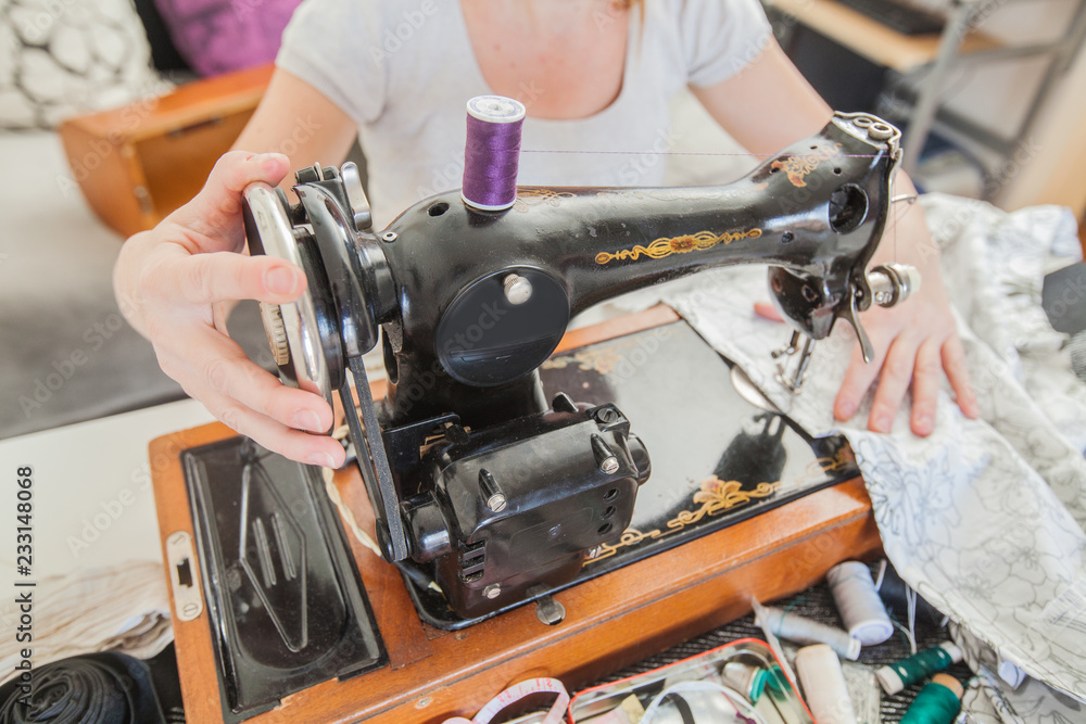Fototapeta premium Female Tailor Using Retro Sewing Machine At Home