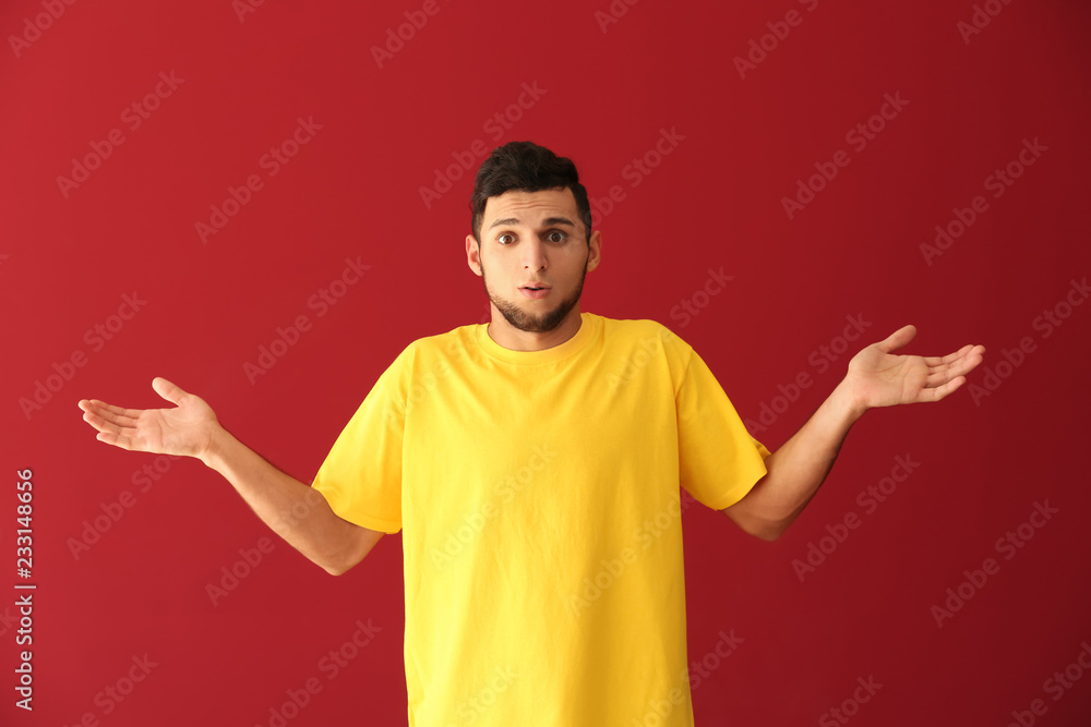 Emotional young man after making mistake on color background Emotional young man after making mistake on color background