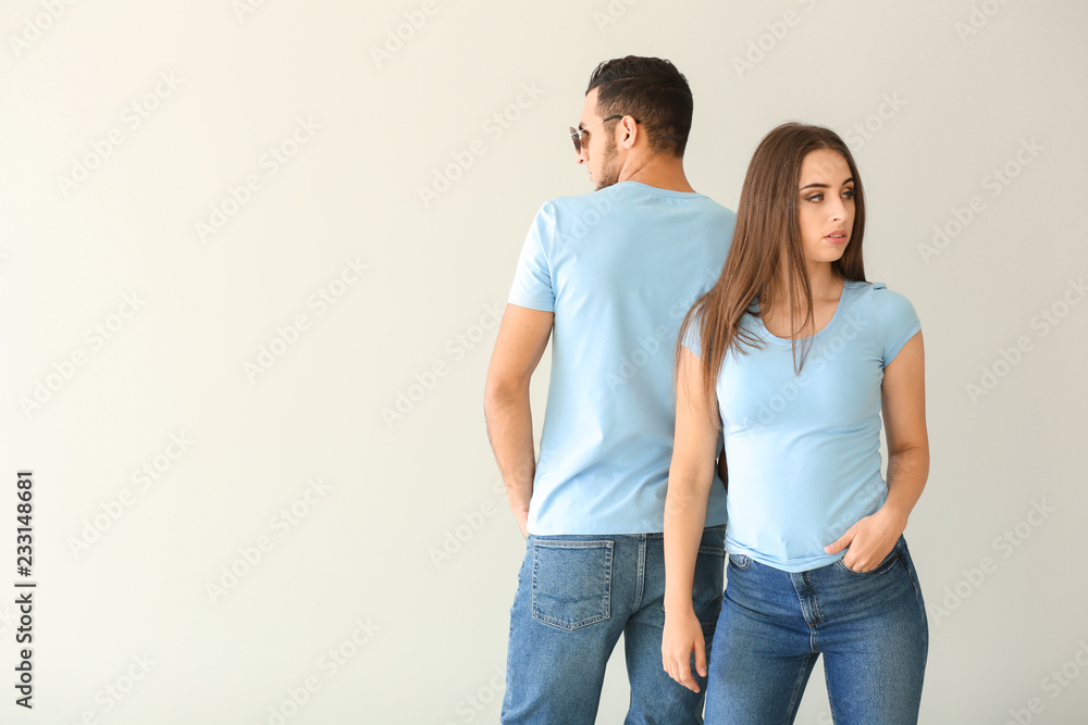 Young man and woman in stylish t-shirts on white background Young man and woman in stylish t-shirts on white background