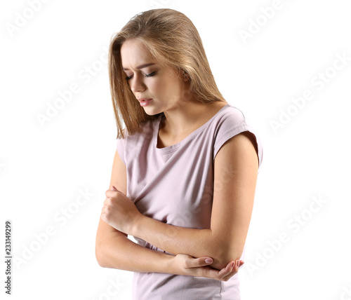 Young woman suffering from pain in elbow on white background © Pixel-Shot