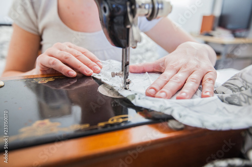 Female Tailor Using Retro Sewing Machine At Home