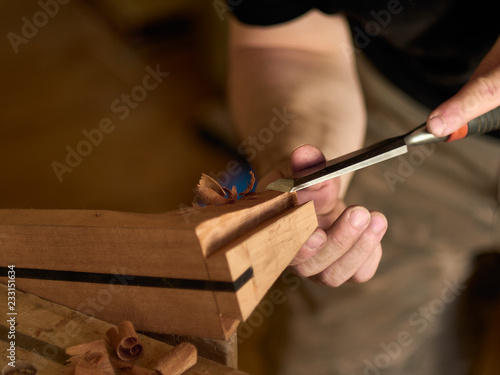 Luthier makes a neck block on a classical guitar. photo