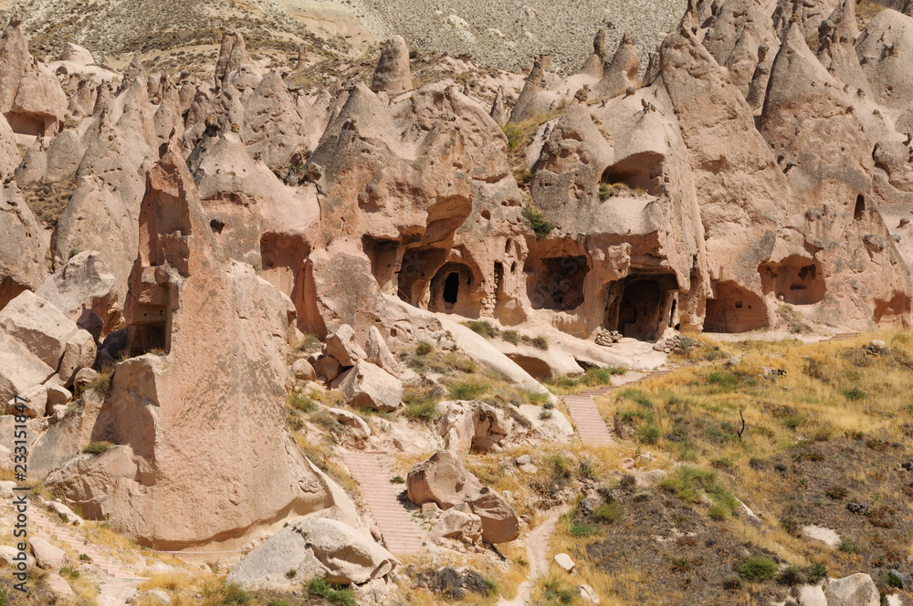 View of cave house from Cappadocia. Impressive fairy chimneys of sandstone in the canyon near Cavusin village, Cappadocia, Nevsehir Province in the Central Anatolia Region of Turkey.