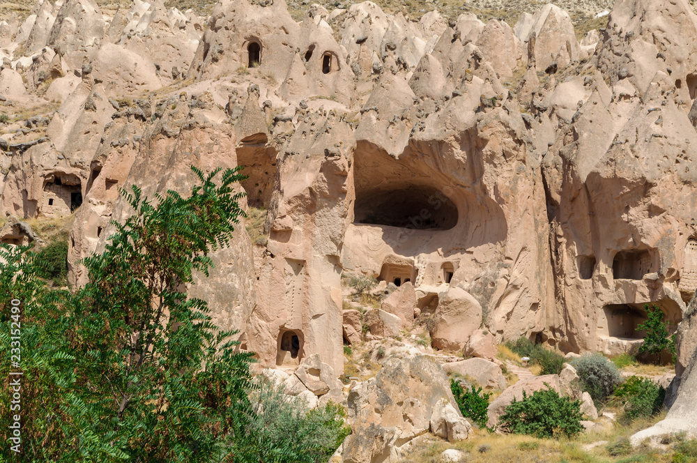 View of cave house from Cappadocia. Impressive fairy chimneys of sandstone in the canyon near Cavusin village, Cappadocia, Nevsehir Province in the Central Anatolia Region of Turkey.