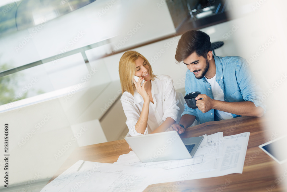 Obraz premium Handsome young man and attractive woman working on laptop