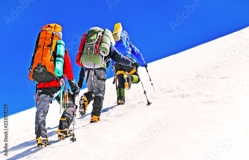 Group of climbers ascending the top of mountain peak. Climbing and mountaineering sport. Teamwork concept.