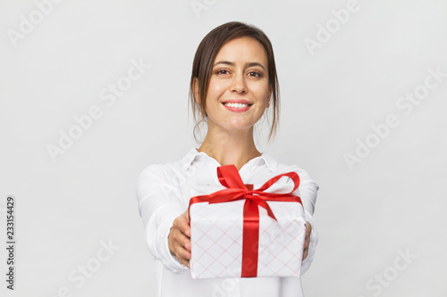 Young beautiful businesswoman with smile giving a present. White background