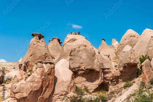 Close up fairy chimneys from Cappadocia. Impressive fairy chimneys of sandstone in the canyon near Cavusin village, Cappadocia, Nevsehir Province in the Central Anatolia Region of Turkey.