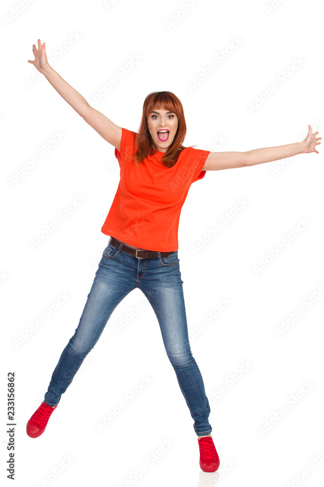 Casual Young Woman Is Standing On One Leg, Holding Arms Outstretched And Shouting