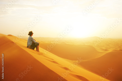 Sand dunes in the Sahara desert. Girl  between sand dunes. Landscape at Sunrise. Morocco  Africa.