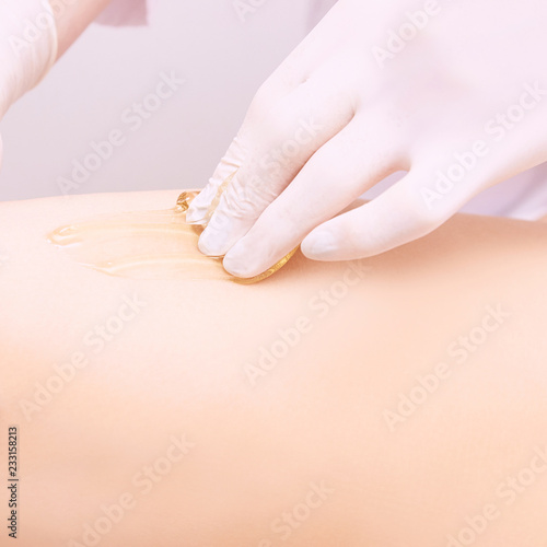 Depilation spa procedure. Woman hair remove waxing. Epilation sugaring. Legs foot