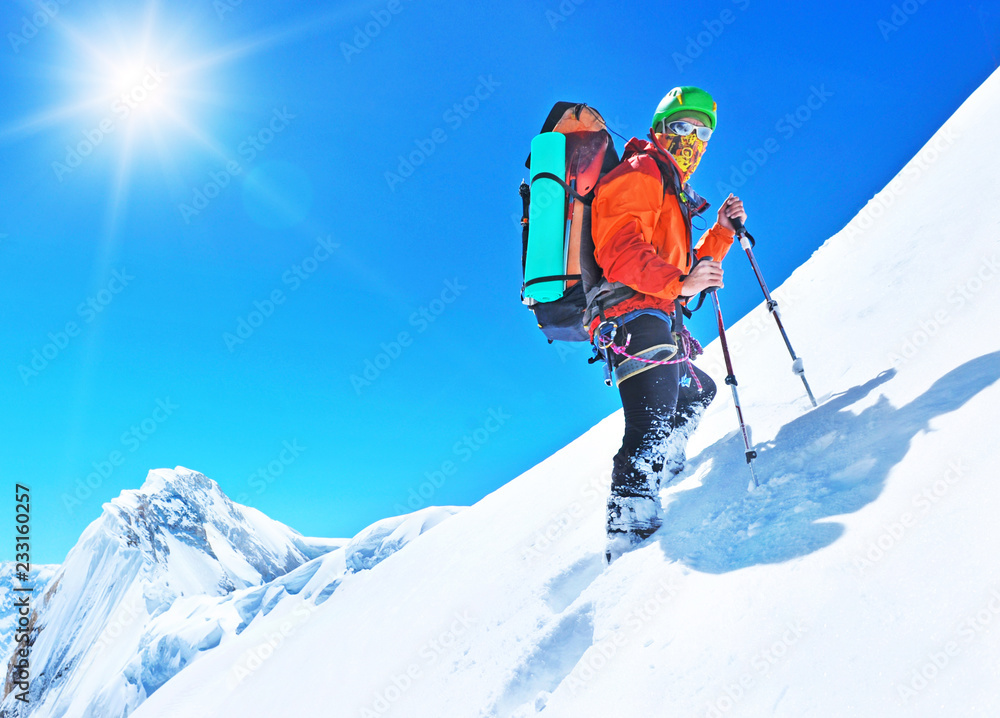  A climber reaching the summit of the mountain. Extreme sport concept