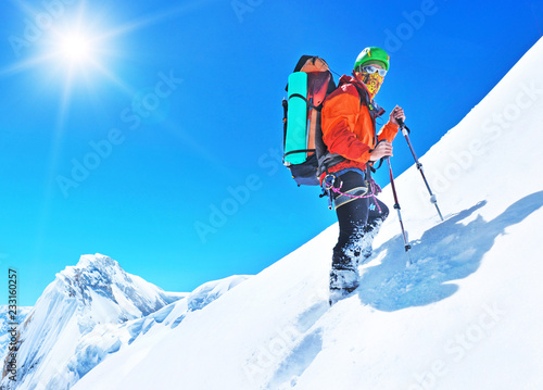  A climber reaching the summit of the mountain. Extreme sport concept