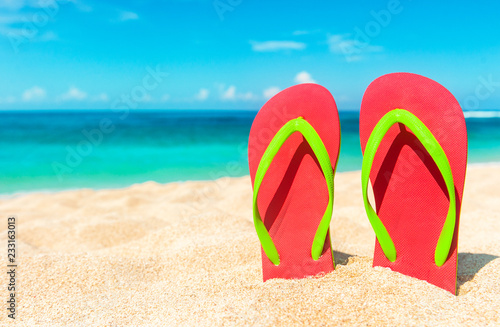 Beach sandals on the sandy coast. Summer holiday and vacation concept.