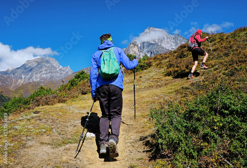 Hiker with backpacks enjoy the track to Everest Base Camp. Success, freedom and happiness, achievement in mountains. Active sport concept.