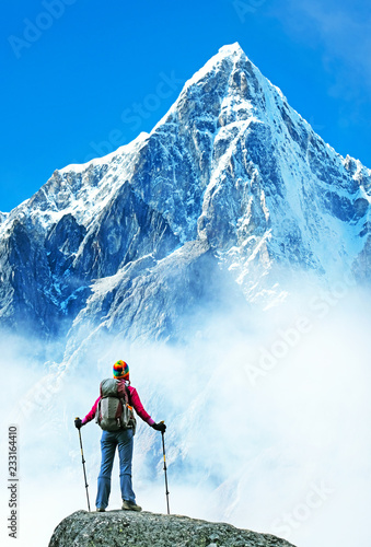 Young woman, hiker with backpack enjoys the view on valley in mountains. Success, freedom and happiness, achievement in mountains. Active sport concept.