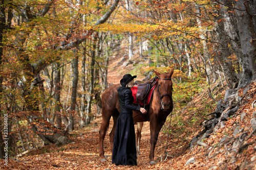 Woman near the horse in the autumn forest © yanakoroleva27
