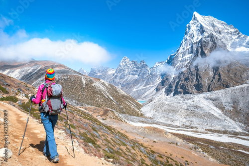 Hiker with backpacks reaches the summit of mountain peak. Success, freedom and happiness, achievement in mountains. Active sport concept.