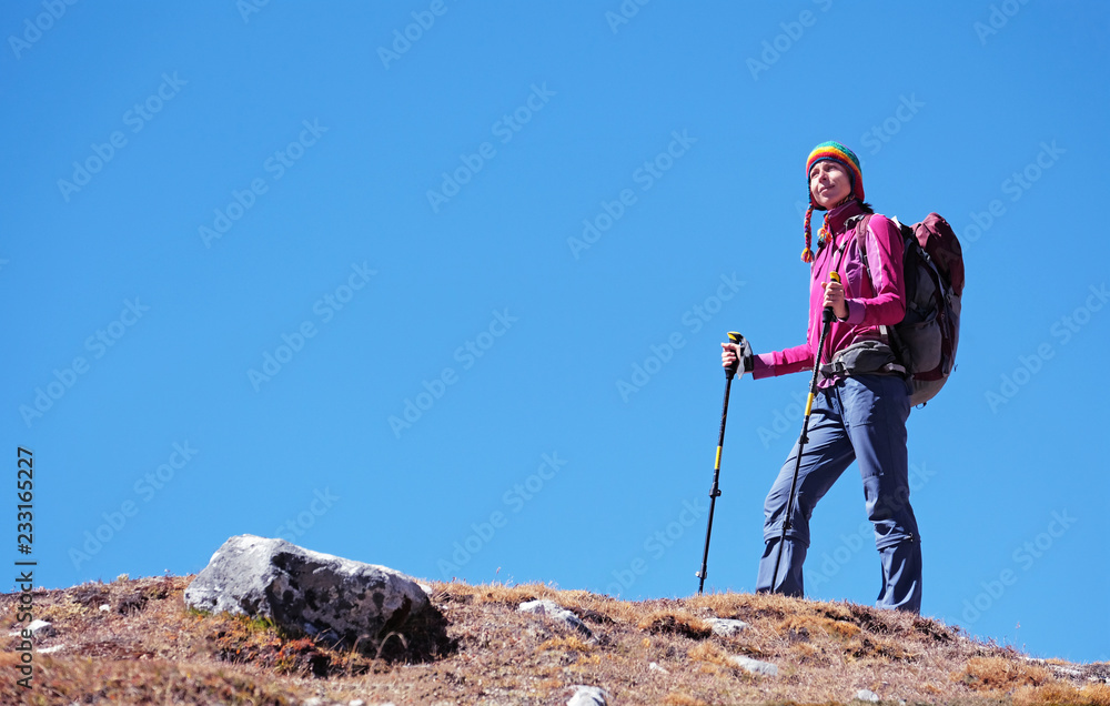 Young woman, hiker with backpacks reaches the summit of mountain peak. Success, freedom and happiness, achievement in mountains. Active sport concept.