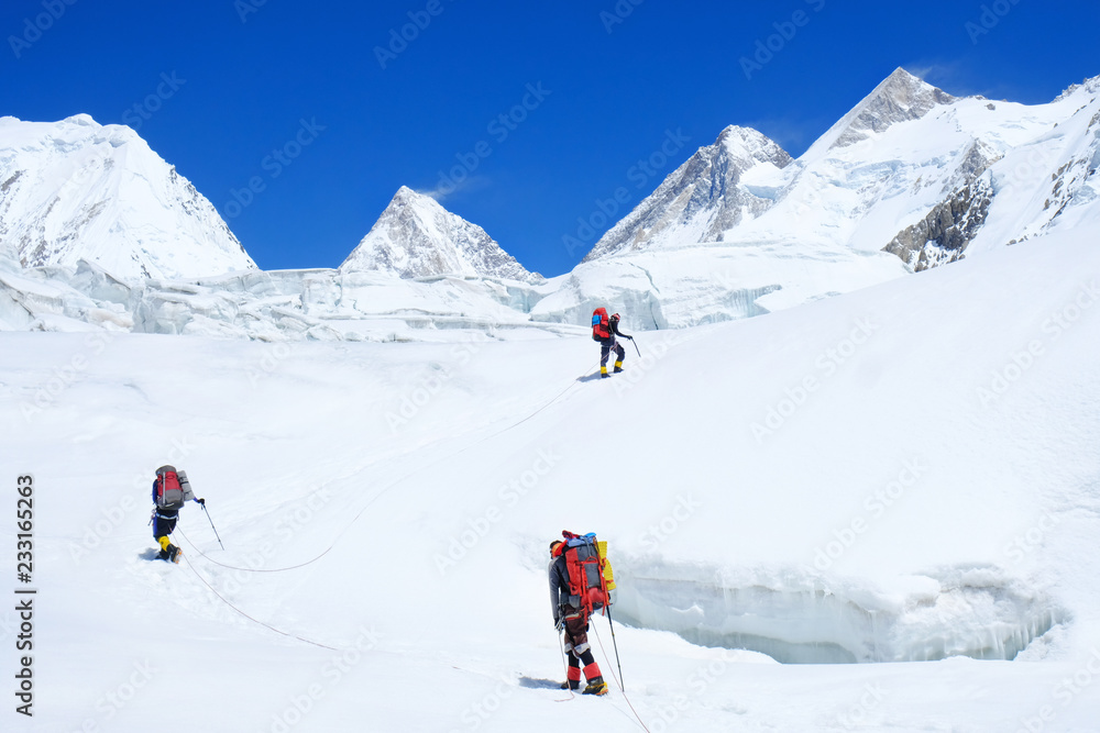 Climber reache the summit of mountain peak. Three climber on the glacier. Success, freedom and happiness, achievement in mountains. Climbing sport concept.