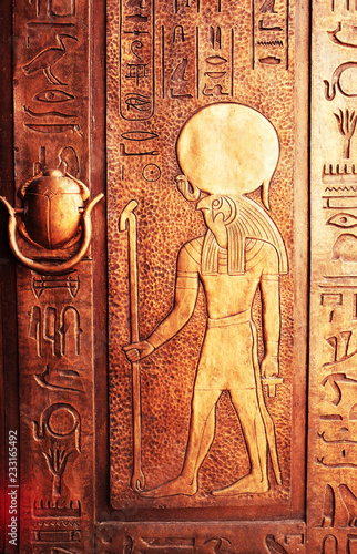 Egyptian hieroglyphs on the door. Hieroglyphic carvings on the exterior walls of an ancient egyptian temple