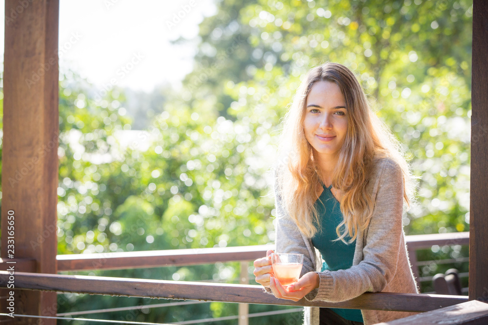 Young woman drinking herbal tea outdoors Young woman drinking herbal tea outdoors