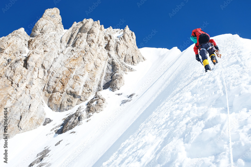Climber reache the summit of mountain peak. Success, freedom and happiness, achievement in mountains. Climbing sport concept.