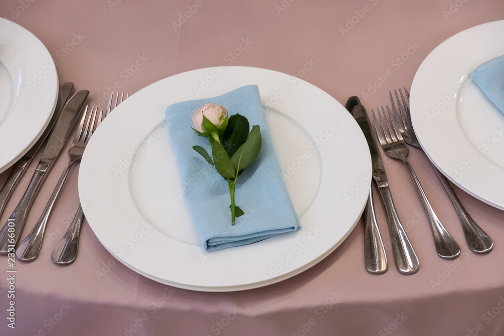 Table with a pink tablecloth, served and decorated with roses Table with a pink tablecloth, served and decorated with roses