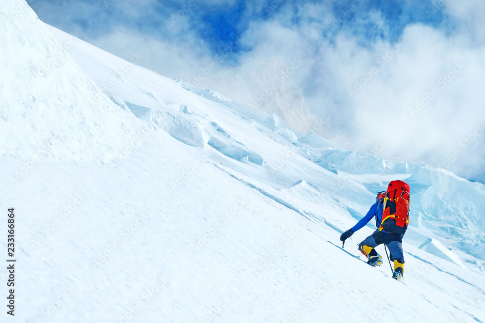 Climber with backpacks reaches the summit of mountain peak Everest. Success, freedom and happiness, achievement in mountains. Active sport concept.