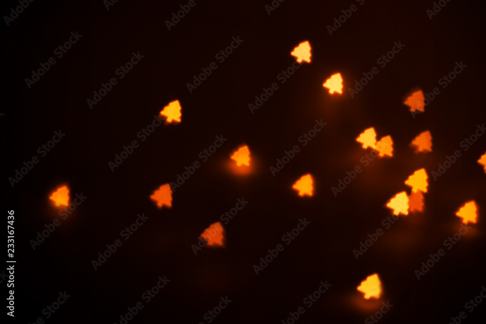 Beautiful figured boke from a garland of warm light in the form of a Christmas tree on a dark background. Conceptual New Year's photo. Beautiful figured boke from a garland of warm light in the form of a Christmas tree on a dark background. Conceptual New Year's photo.