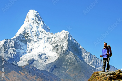 Beautiful view of Ama Dablam with backpacker. Everest base camb trek. Success, freedom and happiness, achievement in mountains. Active sport concept.