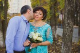 Mature plus size bride with groom at park, life of middle aged women. Concept of marriage with younger man 