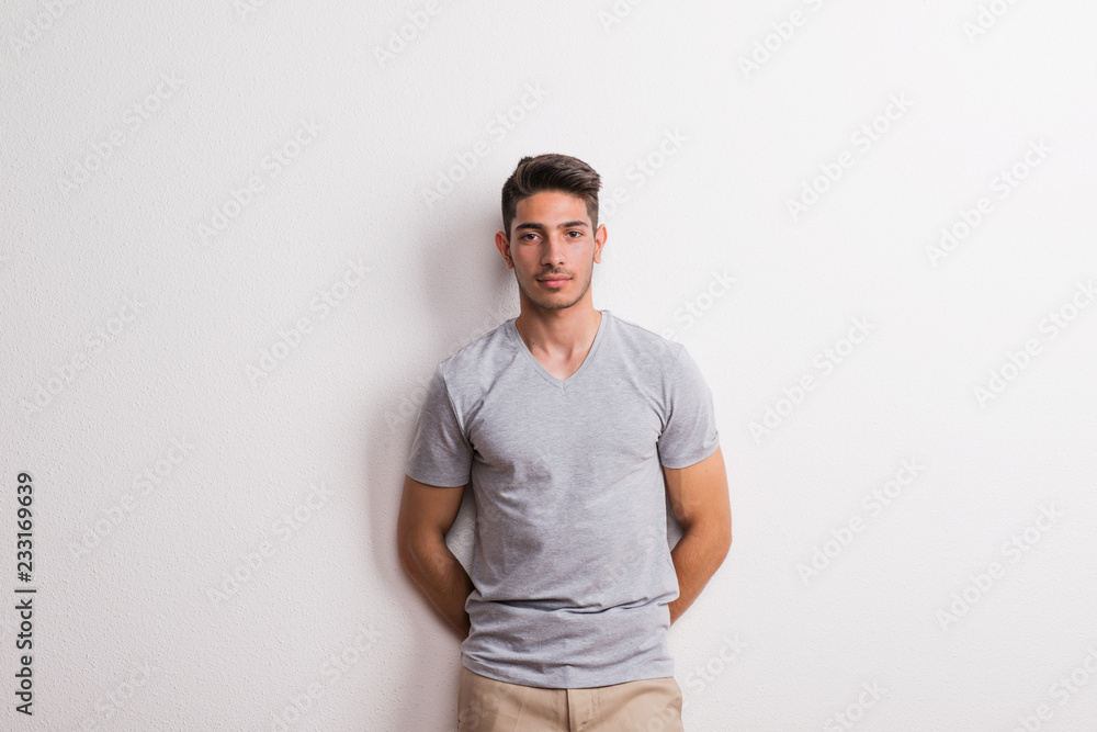 A cheerful young hispanic man standing in a studio. A cheerful young hispanic man standing in a studio.