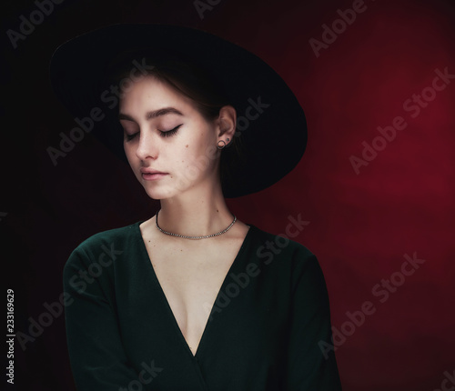 Beautiful, young girl in a stylish felt hat with wide brim sad and nostalgic