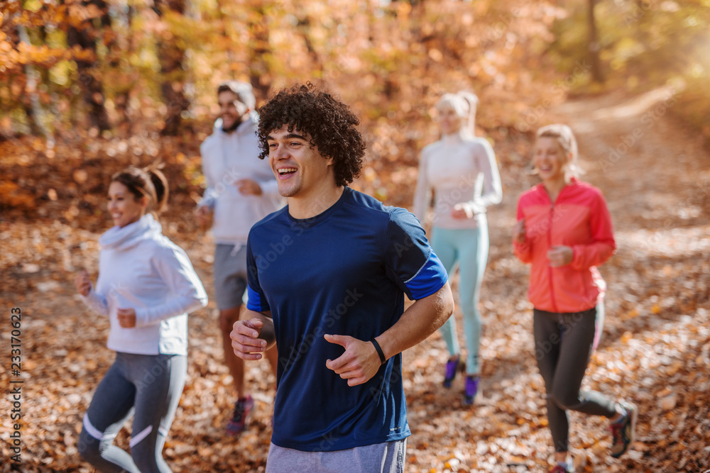 Small group of people running in woods.