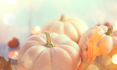 Thanksgiving background. Holiday scene. Wooden table, decorated with pumpkins, autumn leaves and candles