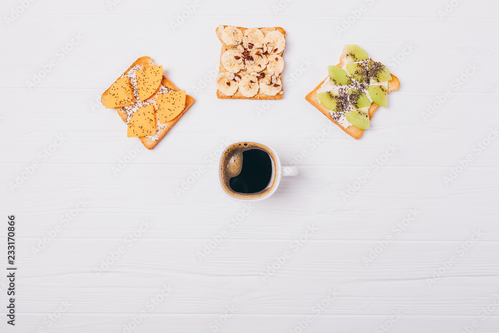 Cup of coffee and three different fruit toast, top view Cup of coffee and three different fruit toast, top view