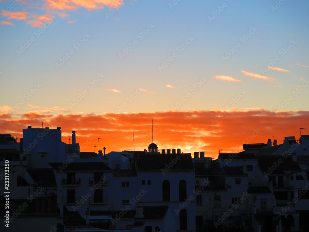 Orange dawn clouds in Andalusian village