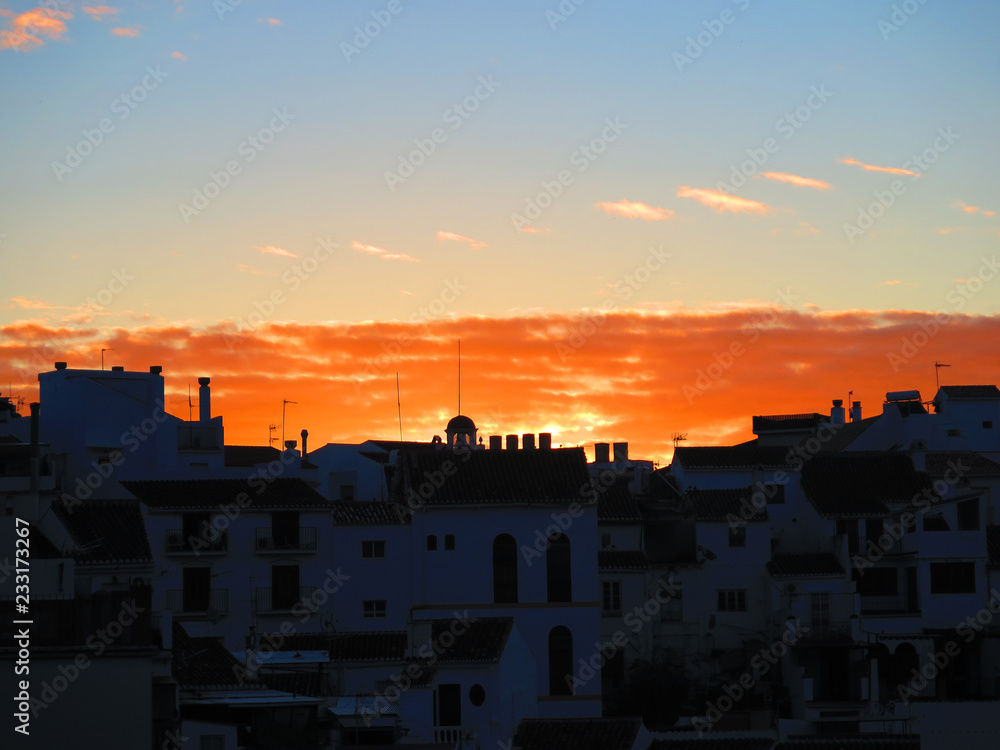Orange dawn clouds in Andalusian village