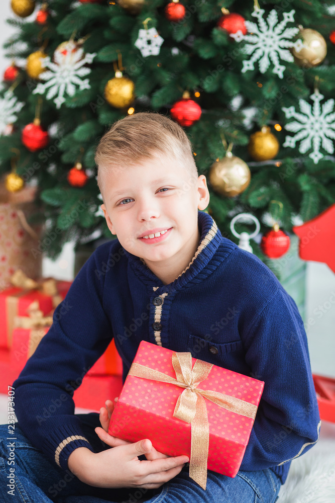 Closeup portrait of happy smiling young kid in home festively decorated Christmas interior. Vertical color photography. Closeup portrait of happy smiling young kid in home festively decorated Christmas interior. Vertical color photography.