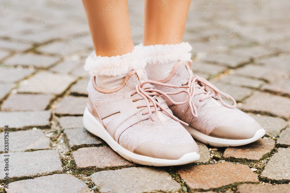 Woman wearing new comfy trainers and soft pink ruffle socks, close up image