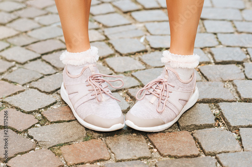 Woman wearing new comfy trainers and soft pink ruffle socks  close up image