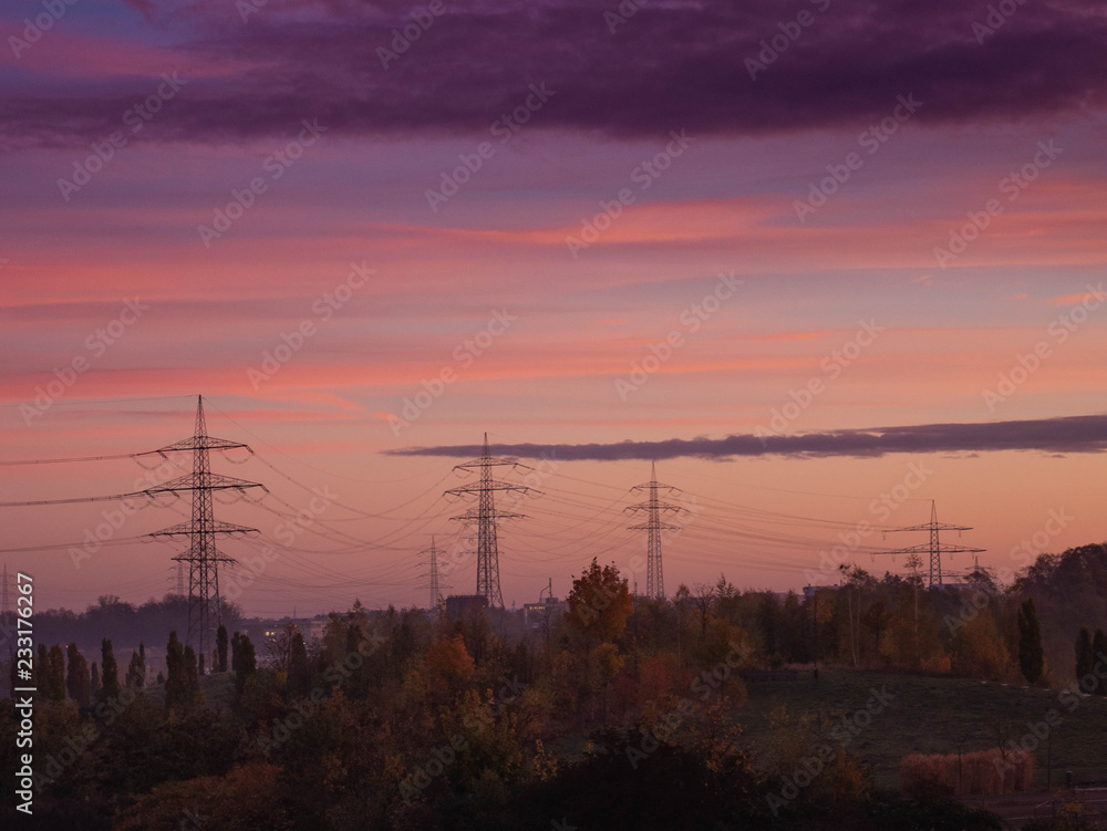 Stromtrasse im Ruhrgebiet bei rötlich violettem Morgenlicht Stromtrasse im Ruhrgebiet bei rötlich violettem Morgenlicht