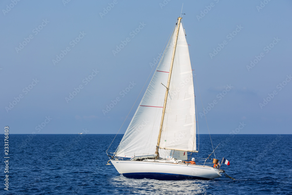 A small French registered sailing yacht cruises the waves outside Monterosso al Mare in Italy