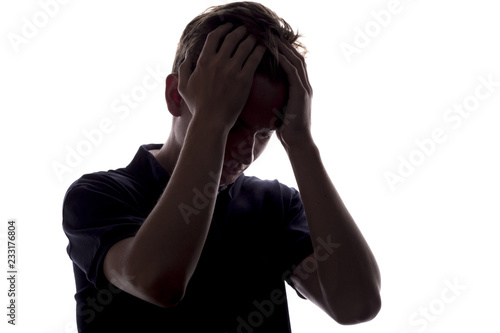 silhouette of a upset guy on a white isolated background, young man with hand near forehead