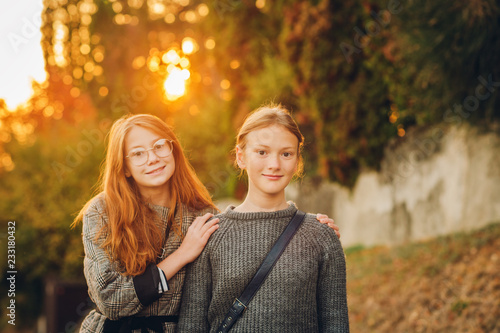 Outdoor sunset portrait of two young preteen girls