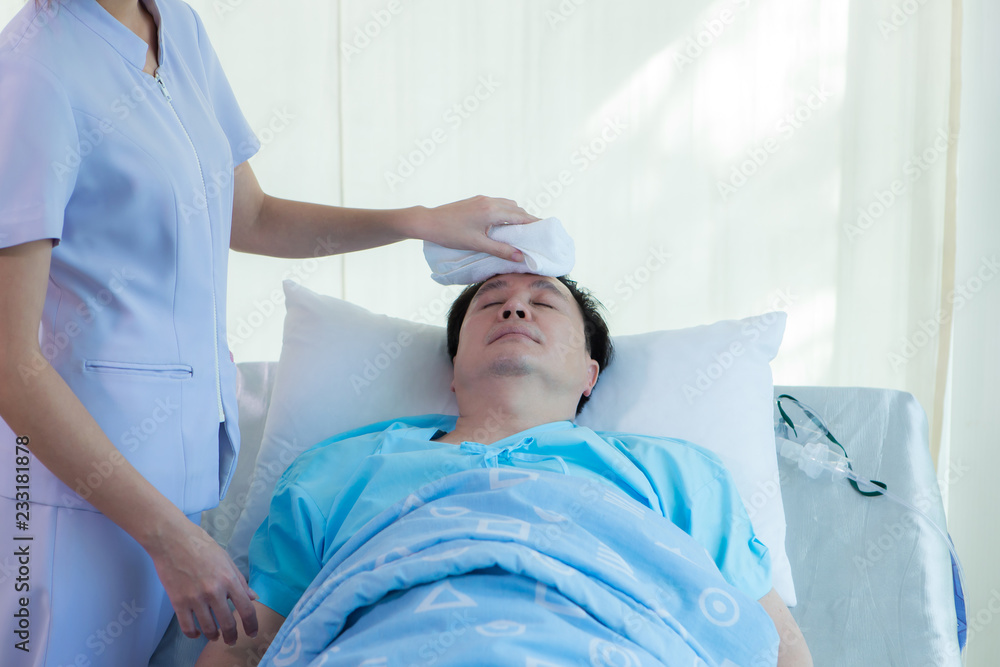 Fototapeta premium Nurse reassuring her patient on bed in hospital / healthcare medical concept. copy space